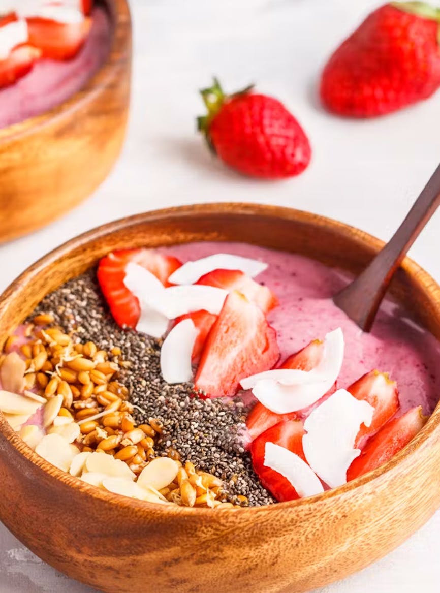 Three images: a person pouring a premier protein shake into a glass. A wooden bowl of strawberries with grains and protein yogurt. chocolate protein cupcakes with mint garnish